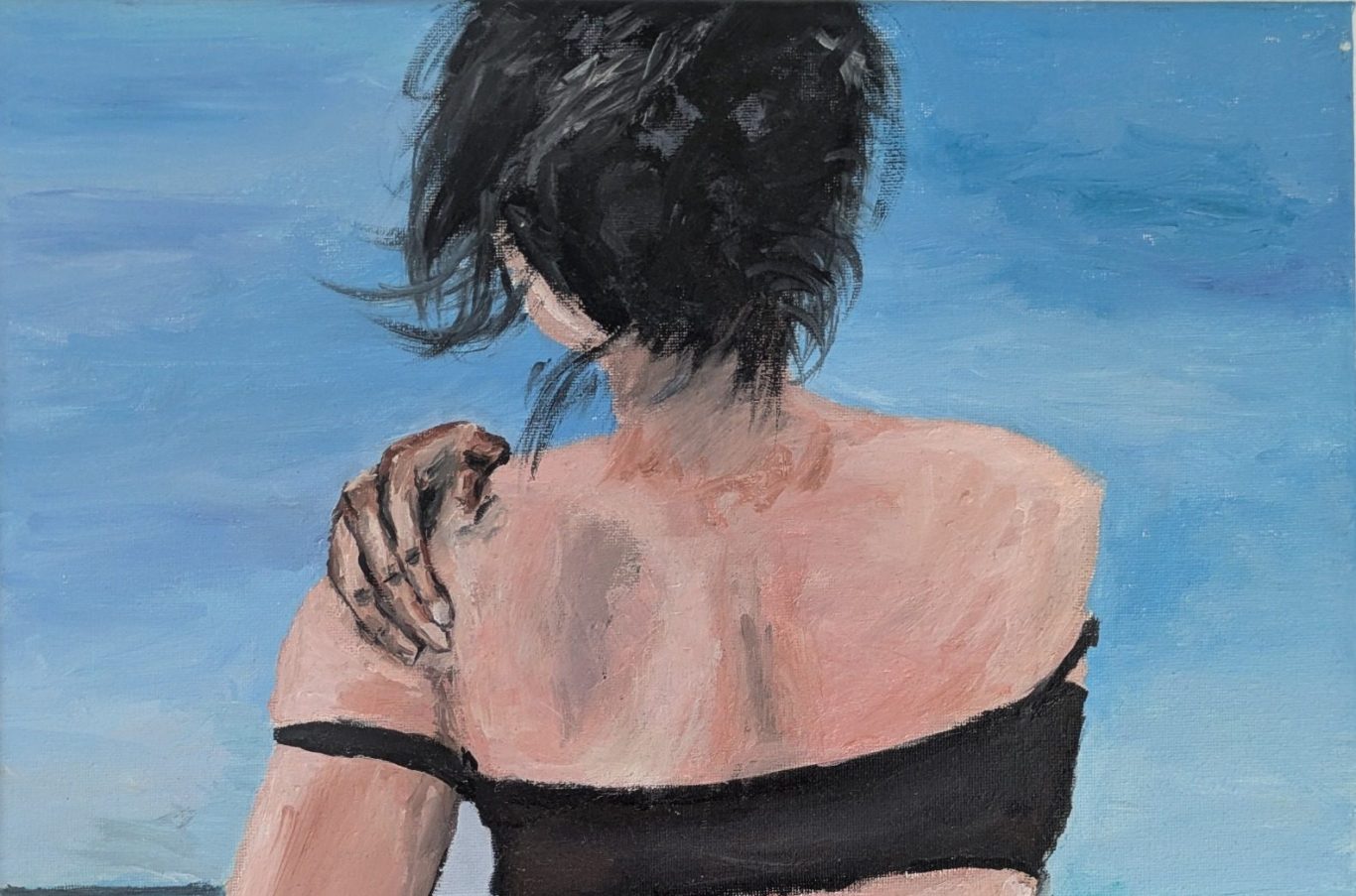 Eine Person mit schwarzem Oberteil blickt auf einen blauen Himmel und das Meer.